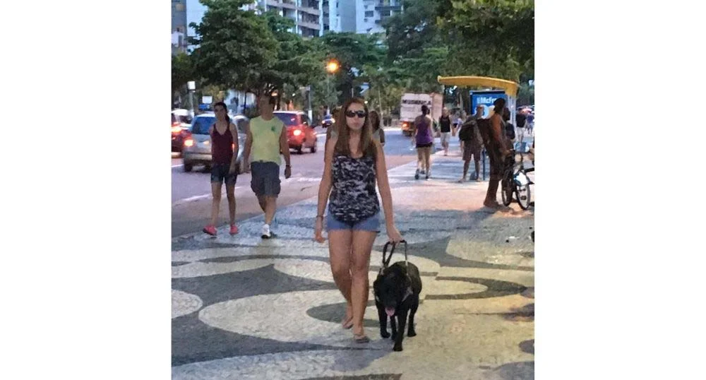 A cão guia Hilary ajuda Mel a se orientar na rua e em qualquer outro lugar